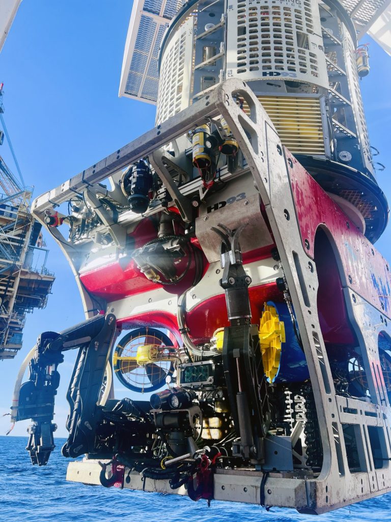 Underwater ROV for offshore construction coming out of water near drilling platform